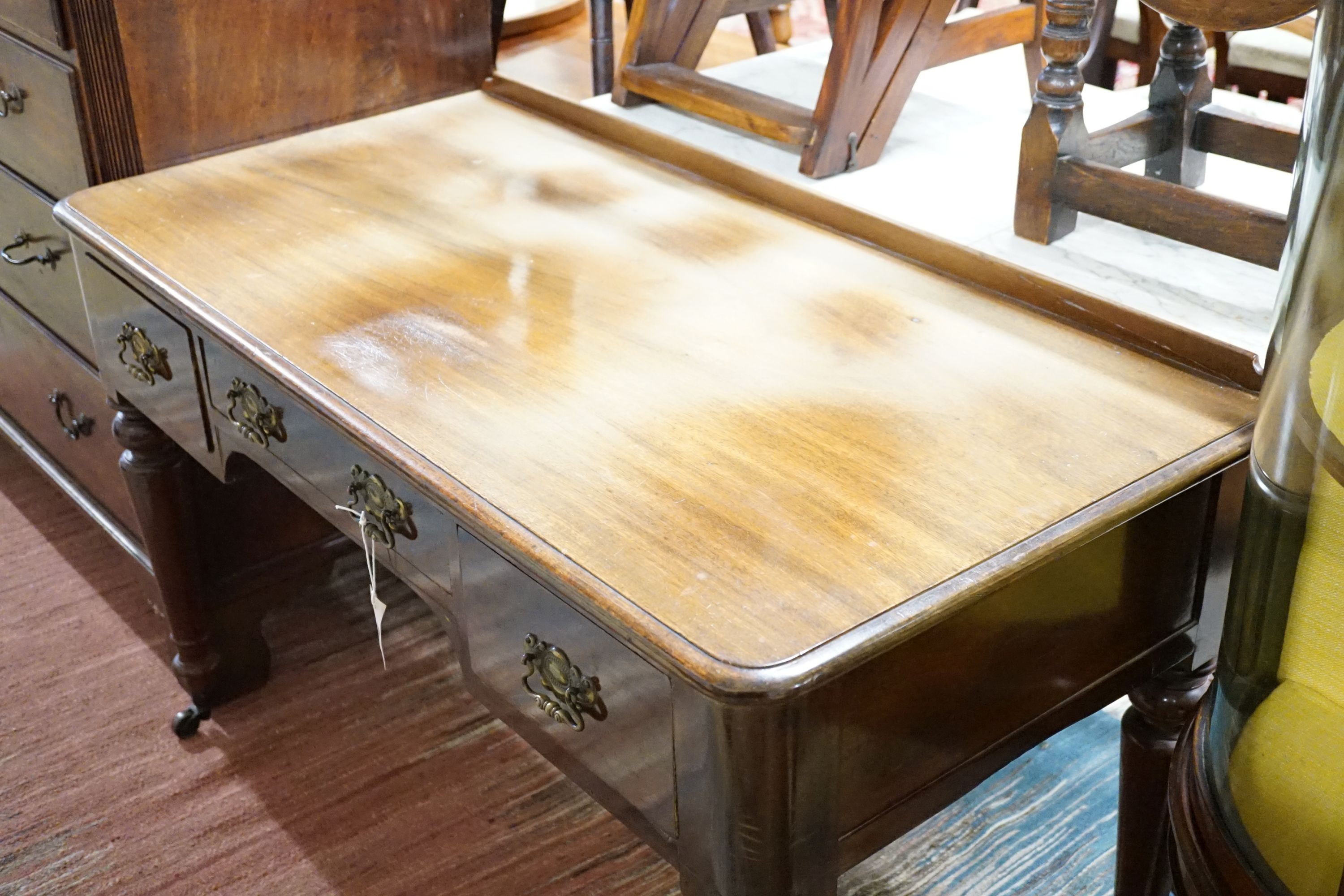 A Victorian mahogany writing table fitted three frieze drawers and turned tapering legs on castors, 121 cm wide, 59 cm deep, 77 cm high